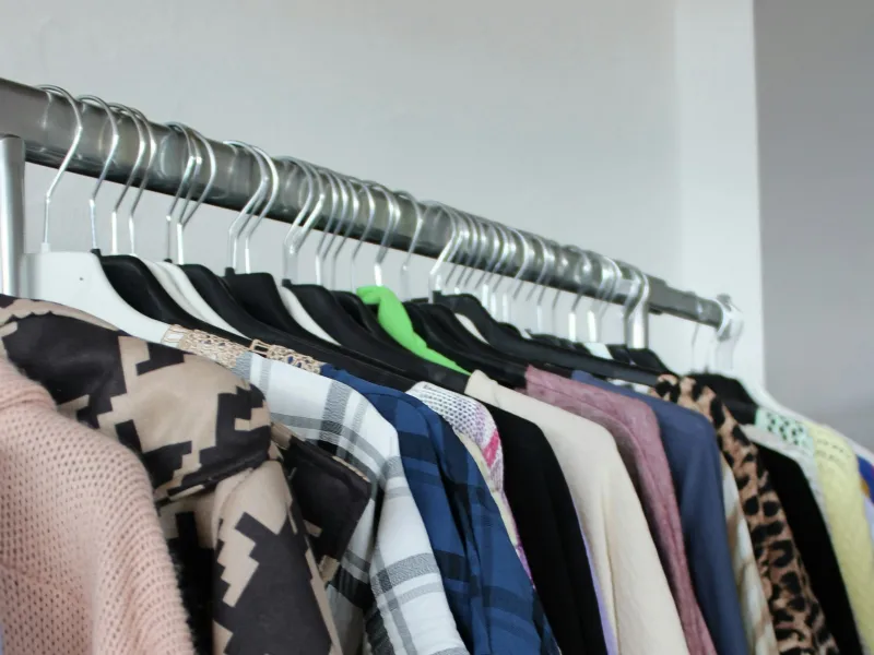 Casual clothes hanging on a metal clothes rail