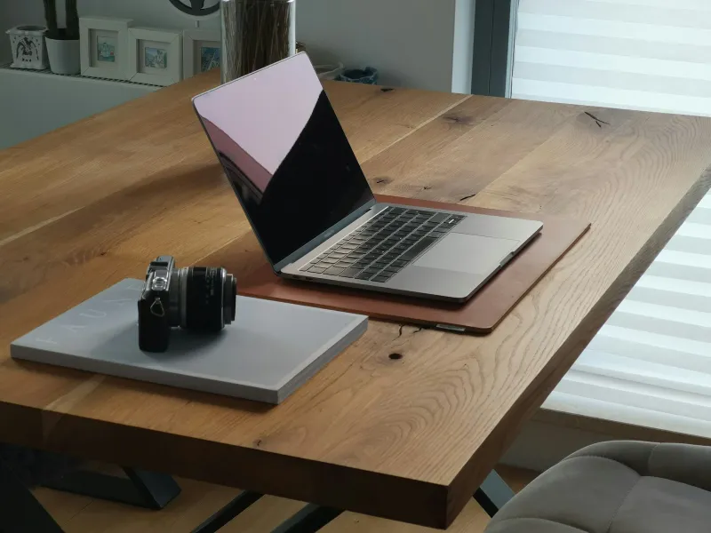 Intego: Mac-first security software in one app An open laptop on a wooden desk beside a camera resting on a book