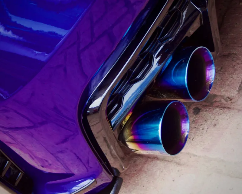 Twin blue-tinted exhaust tips under the rear bumper of a purple car