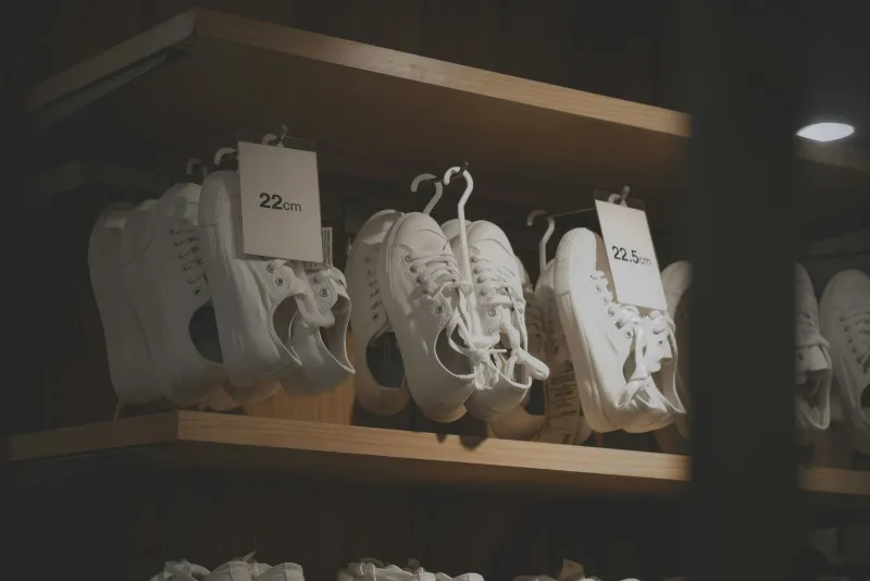 JD Sports spotlight: autumn trainers worth a look and how to pay less White canvas trainers hanging on a wooden shop shelf with size tags