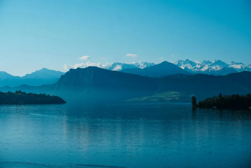 Lake Lucerne with snow-capped Swiss Alps behind under a clear blue sky