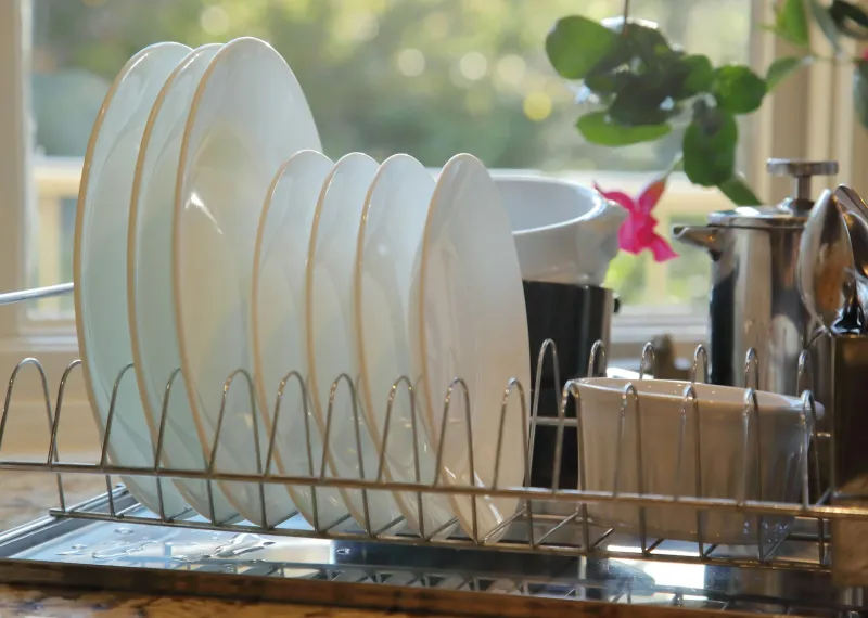 Loch Electronics: Capsule countertop dishwashers from Edinburgh Clean white plates drying in a stainless steel dish rack by a sunny kitchen window