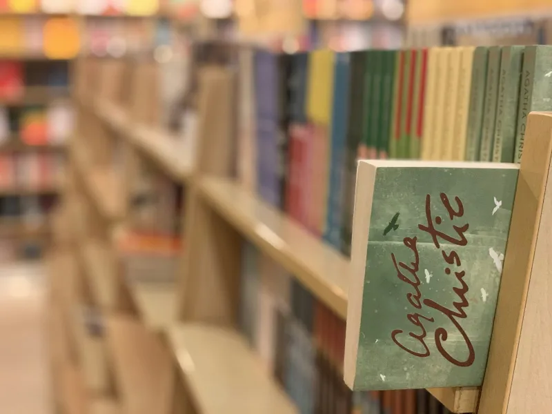 Rows of paperbacks on a bookshop shelf, with the rest of the shop softly out of focus