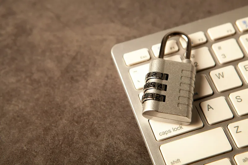 A combination padlock resting on a white computer keyboard