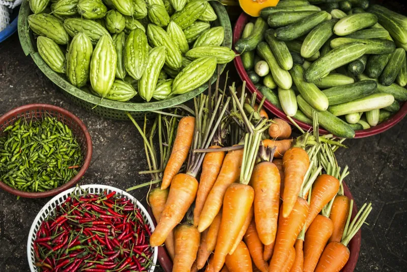 Baskets of fresh carrots, cucumbers, green vegetables and chillies