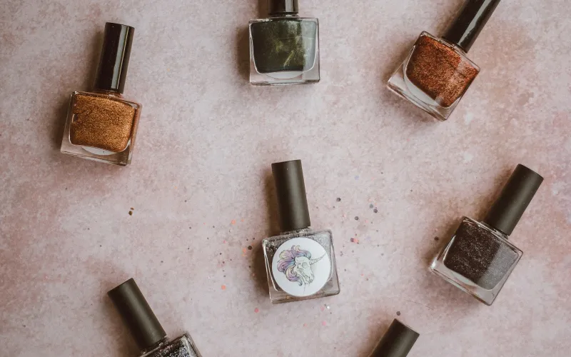 MelodySusie: nail drills, gel lamps and manicure kit for home and salon Bottles of glittery and metallic nail polish laid out on a pink surface
