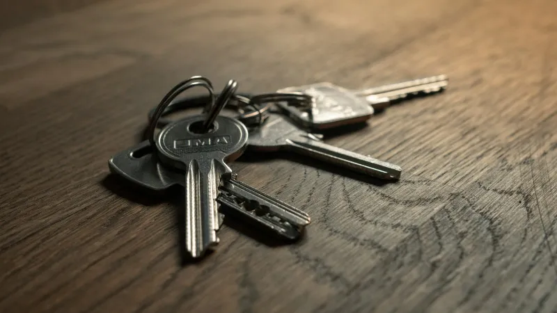 Bunch of house keys on a dark wooden table