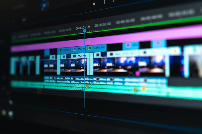 A video editing timeline with colourful clips on a dark screen