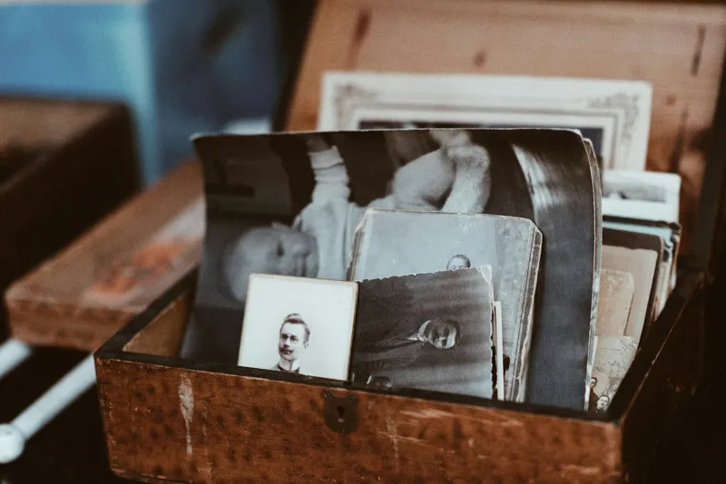 Old black-and-white family photographs in a wooden box
