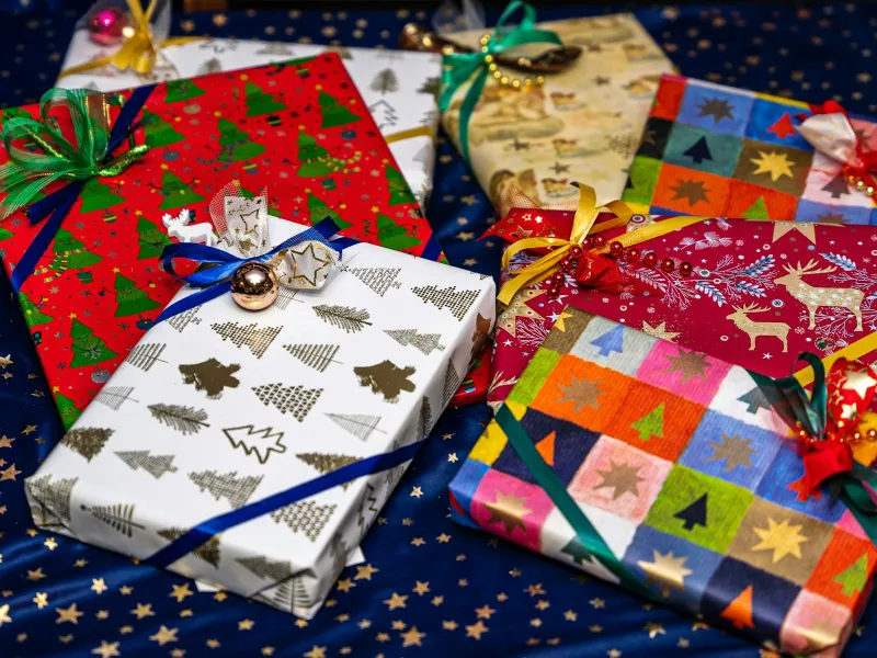 Wrapped presents in patterned paper with ribbons on a starry cloth