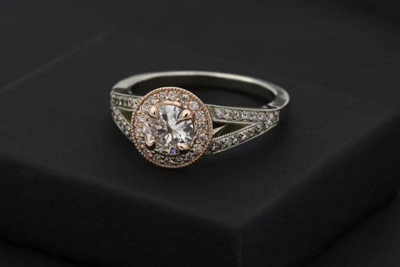 A silver diamond ring sitting in a black ring box