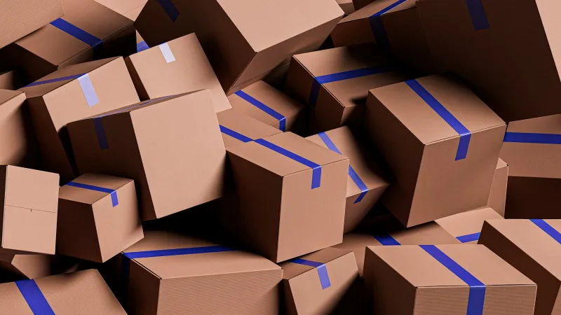 A pile of brown cardboard boxes sealed with blue tape