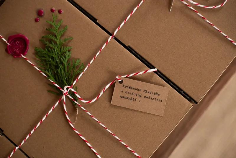 Brown gift boxes tied with red and white twine and a handwritten gift tag