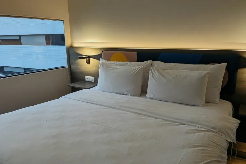 Made-up hotel bed with white pillows and bedding