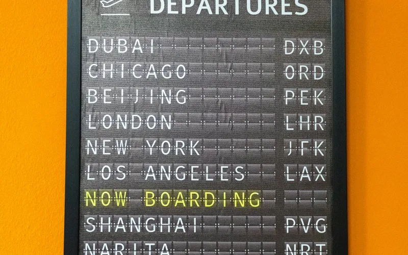 Split-flap style departures board showing flights to cities around the world