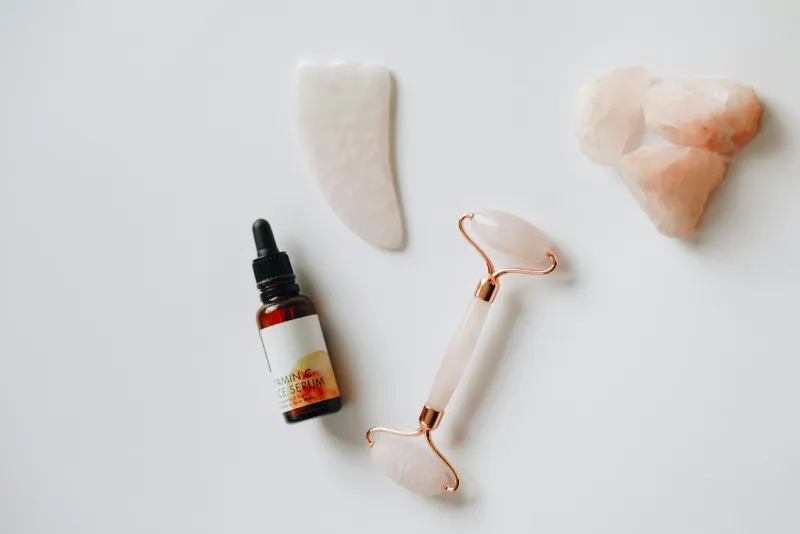 Real Beauty Bargains: branded skincare at clearance prices A serum bottle, gua sha stone and facial roller laid out on a white background