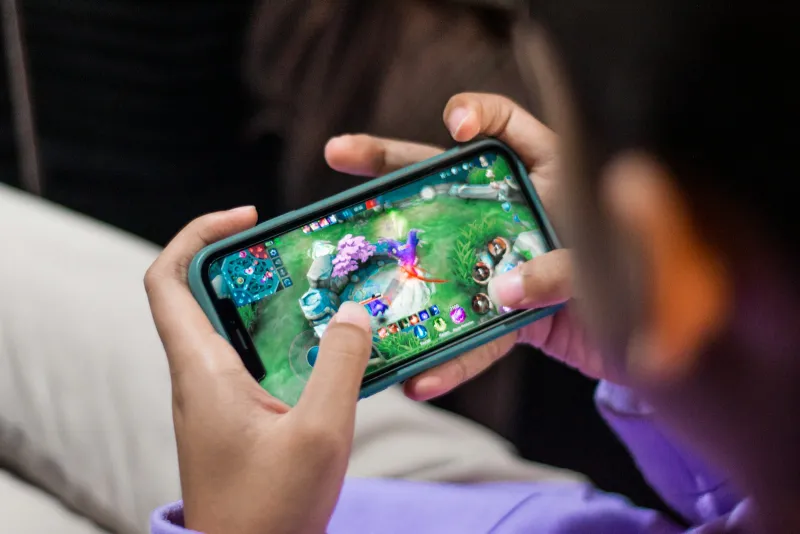 REDMAGIC UK: gaming phones, the Astra 2 tablet and phone coolers Hands holding a smartphone sideways while playing a colourful mobile game