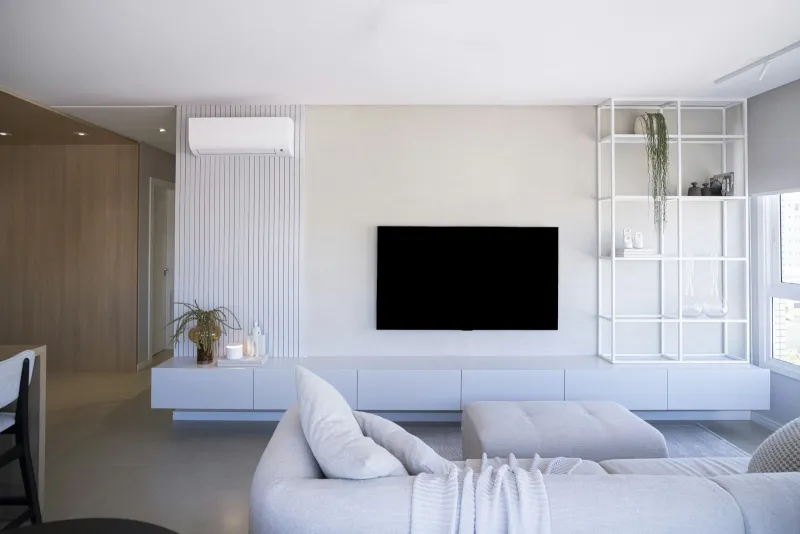 Bright modern living room with a wall-mounted TV and light grey sofa