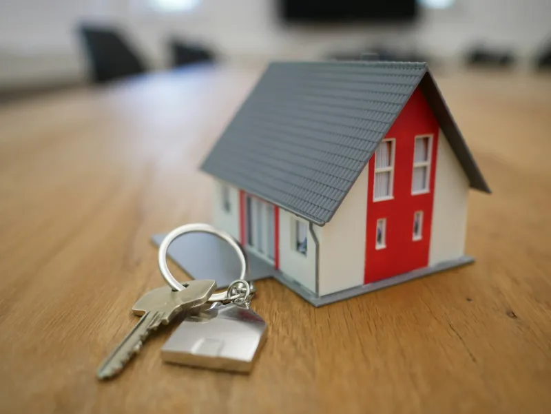 SellTo: selling your home for cash or at auction, and what it costs A small wooden model house on a table, with keys beside it