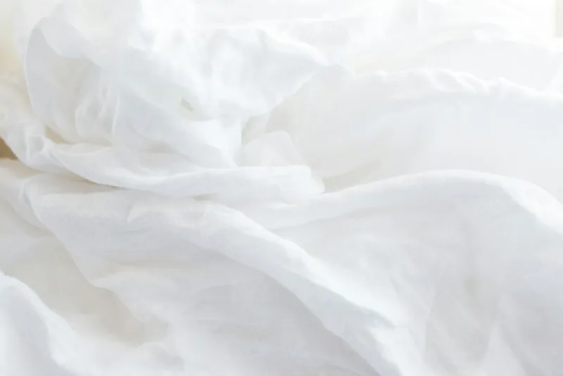 Close-up of soft, crumpled white bed sheets