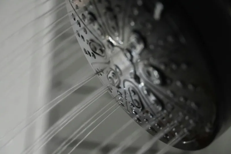Close-up of a chrome shower head with water spraying out