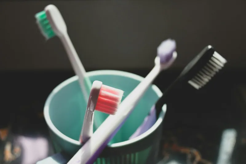 Toothbrushes standing in a teal cup