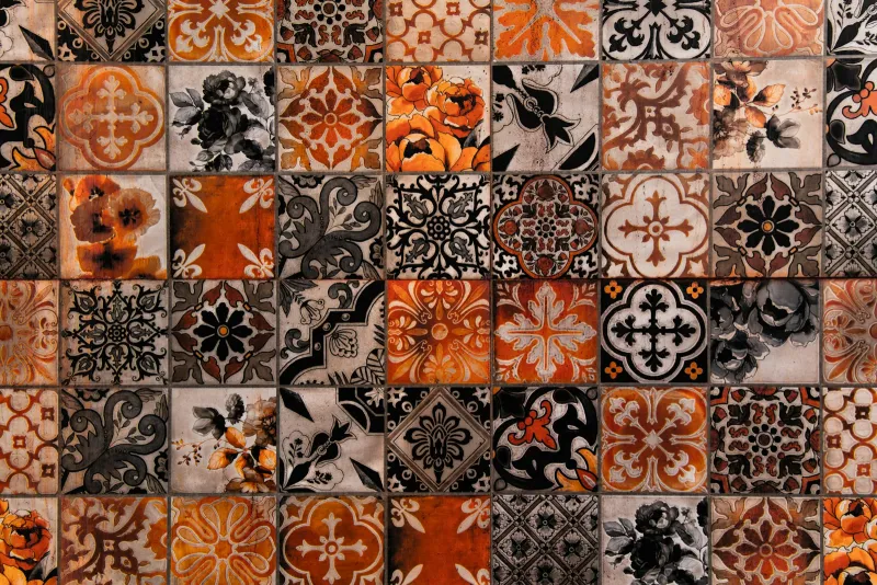 Wall of patterned tiles in orange, black and cream designs