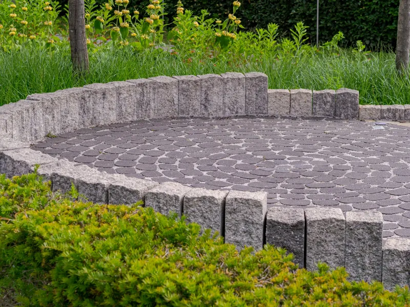 StoneCare4U: UK-made cleaners and sealers for patios, drives and stone Circular paved patio edged by a low stone wall and green shrubs