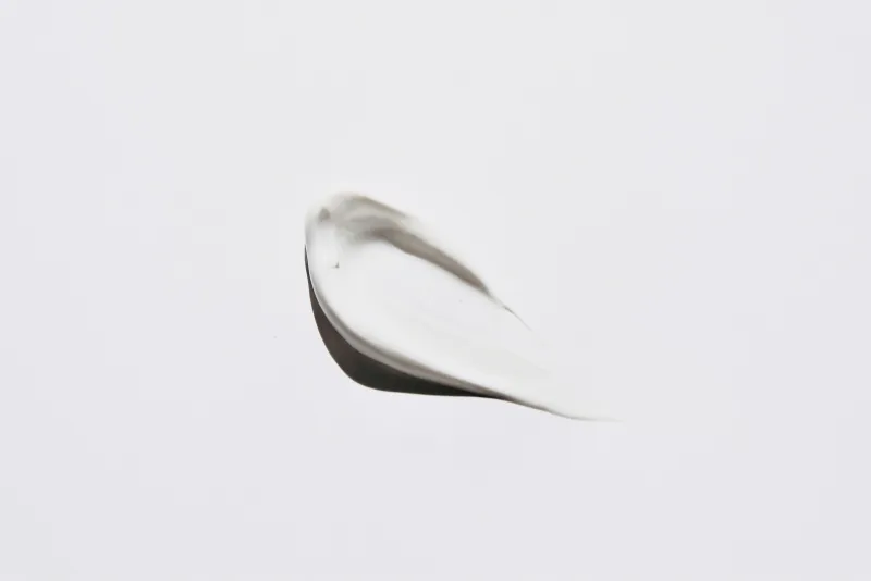A smear of white cosmetic cream on a plain white background