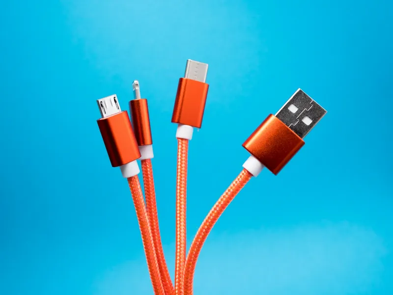 Orange braided charging cables with different connectors against a blue background