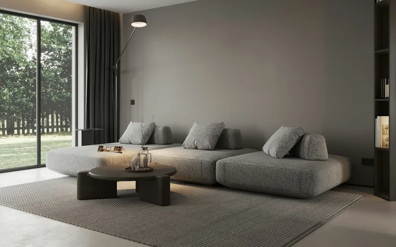 A modern living room with a grey sofa and a large garden window