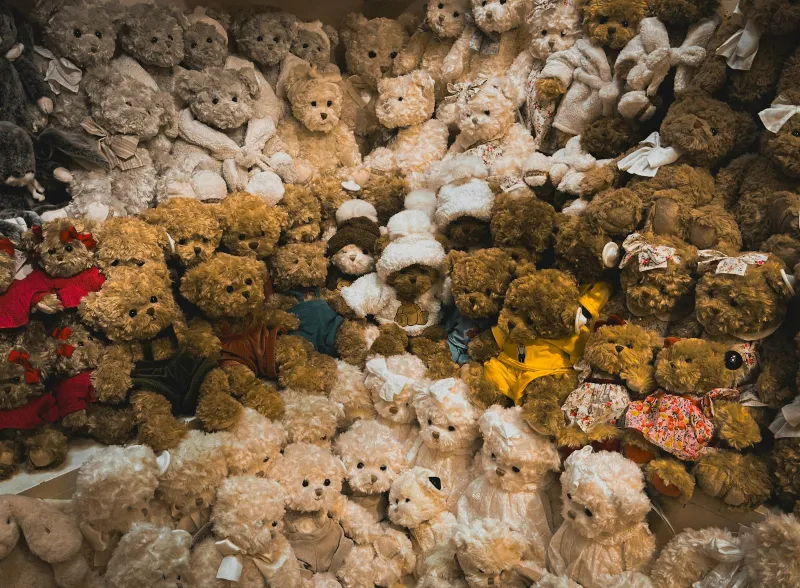 A large collection of teddy bears in different colours and outfits