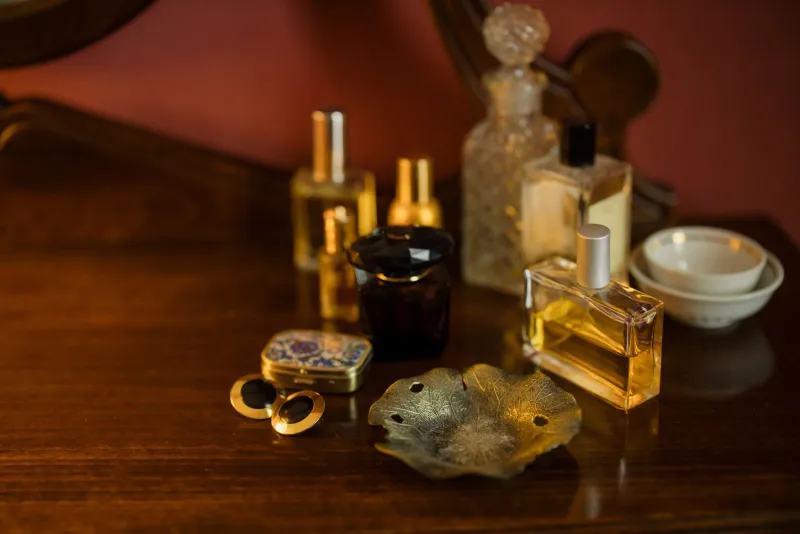 Tenth Muse spotlight: refillable solid perfume and money-saving bundles Perfume bottles and a small compact on a wooden dressing table