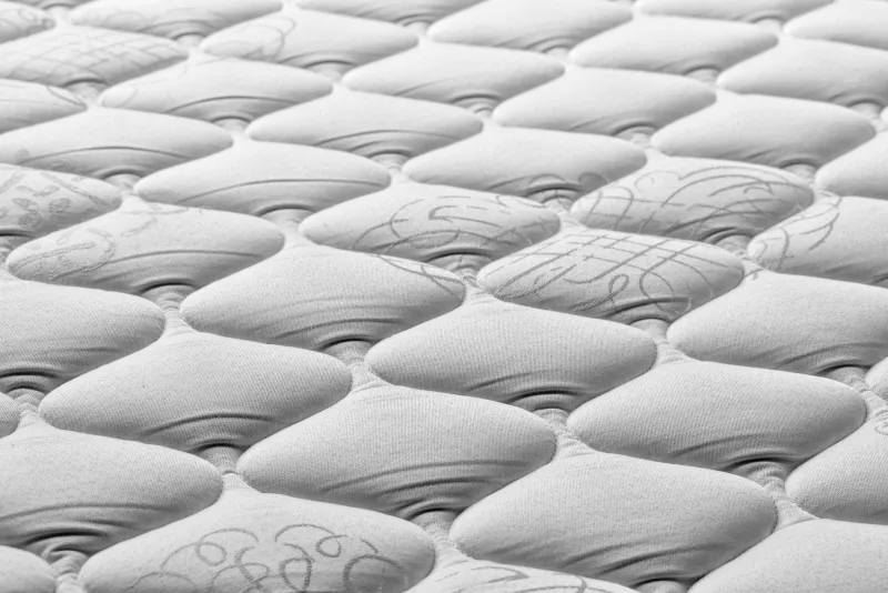 Close-up of a quilted white mattress surface