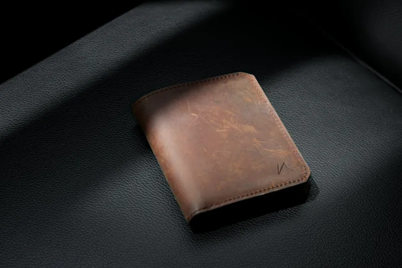 TORRO: leather phone cases, wallets and bags from Newcastle Brown leather bifold wallet resting on black leather