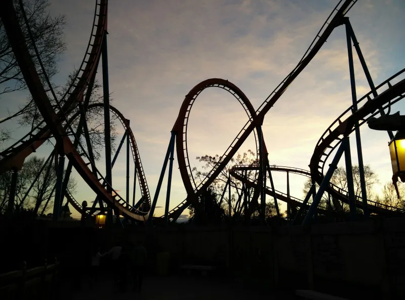Roller coaster loops silhouetted against an evening sky