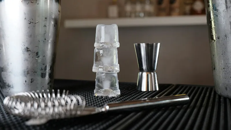 Urban Bar USA: bar tools and cocktail glassware shipped within the US A cocktail shaker, jigger, strainer and stacked ice cubes on a bar mat