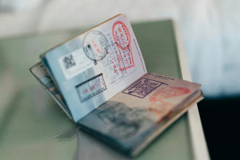 An open passport with colourful entry stamps on its pages