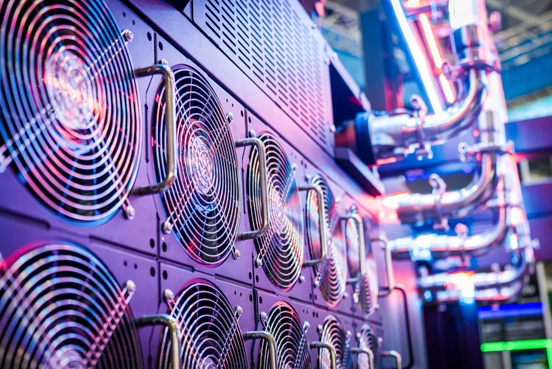 Rows of server cooling fans lit in purple and blue in a data centre