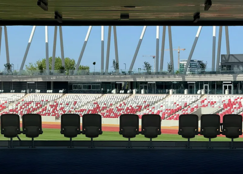 Empty stadium seats and stands under a bright blue sky