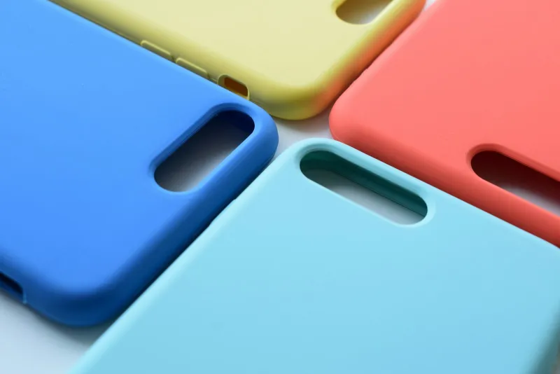Four plain silicone phone cases in blue, yellow, coral and turquoise