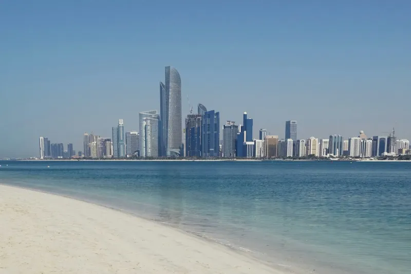 The Abu Dhabi skyline seen across calm water on a clear day